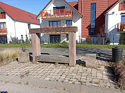 Photo du banc-reposoir en gré des Vosges, disposant de deux traverses superposées l'enssemble est parait recent, indiquant qu'il a sans doute été réstauré.