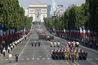 Un immense drapeau tricolore est fixé sous l'Arc de Triomphe lors d'événements importants, comme pour le défilé militaire du 14 Juillet.