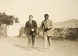Photographie jaunie de deux hommes marchant vers le photographe.
