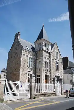 Vue d’une maison en pierre, avec clocheton.