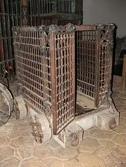 Autre accessoire, une cage en métal sur roues.