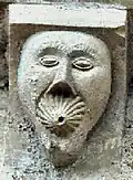 Exemple de modillon : homme avec une espèce de coquillage (un sifflet appelant à rentrer dans l'église[réf.&nbsp;nécessaire]?[style à revoir]), façade nord