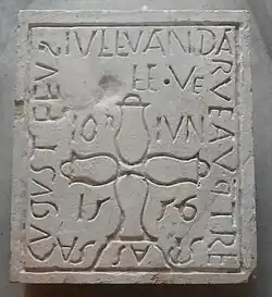 Photographie en couleurs d'une dalle funéraire en pierre portant une inscription et une date, 5 juin 1556.