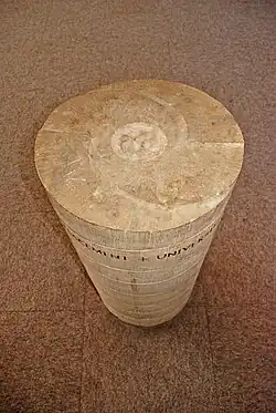 Le sigle qui orne le haut de la pierre.