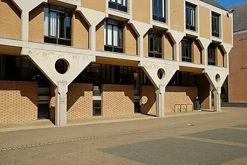 Colonnes de béton blanc soutenant l'étage.