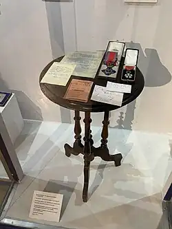 Table sur laquelle on peut apercevoir des médailles dans leur écrin et des documents.