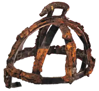 les restes rouillés d'un casque surmontés d'une figurine de sanglier