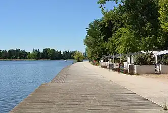 Aménagement des berges, revêtement en bois et un des restaurants installé en bordure du lac