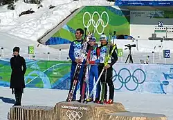 podium de la mass start des jeux de Vancouver. Les trois biathlètes sont ensemble sur la plus haute marche du podium.