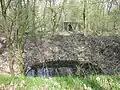 Bunker souterrain allemand situé à côté de l'ancien camp. Cratère de bombe au premier plan