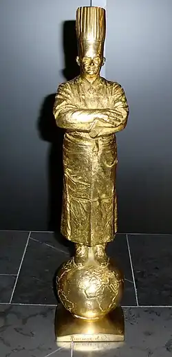 Statuette dorée représentant Bocuse les bras croisés.