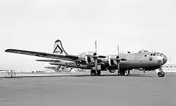 Photo en noir et blanc montrant une vue de trois-quarts avant d'un bombardier à hélices, avec le fuselage gris.