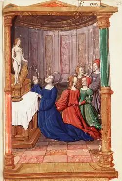 4 dames agenouillées devant l’autel de la déesse nue, un jeune homme déguisé en femme arrive derrières elles.