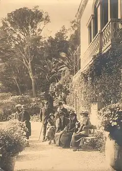 Paul Bourget au Plantier de Costebelle avec Henry Bordeaux et quelques amis, photo d'extérieur, certains sont assis sur un banc