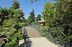 Photographie d'une allée du Jardin Public entourée de buissons verdoyants.