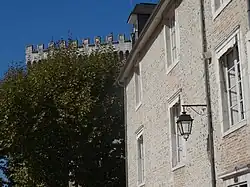 Photographie en couleurs d'un vieille immeuble construit en galets et briques.