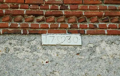 Détail du mur extérieur de la sacristie, portant la date de 1780.