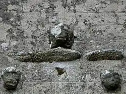 Têtes sculptées ornant la façade ouest de l'église.