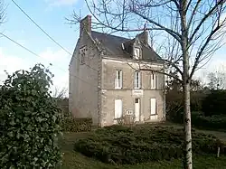 Photographie en couleurs d'un petit bâtiment à étage ; inscription « mairie » au-dessus de la porte.