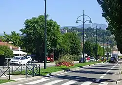 Photographie d'une route départementale accompagnée d'un terre-plein vert.