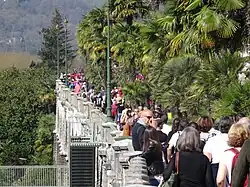 Phohographie en couleurs d'une rue formant belvédère et remplie de passants.
