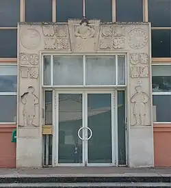 Le portique sculpté de l'école primaire, signé Yvonne Gisclard-Cau et Paul Manaut.