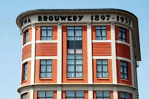 L'inscription «&nbsp;Mena Brouwerij 1897-1933&nbsp;» au sommet de la façade.