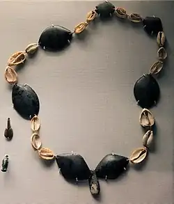 Collier composé de coquillages et des pierres noires polies.