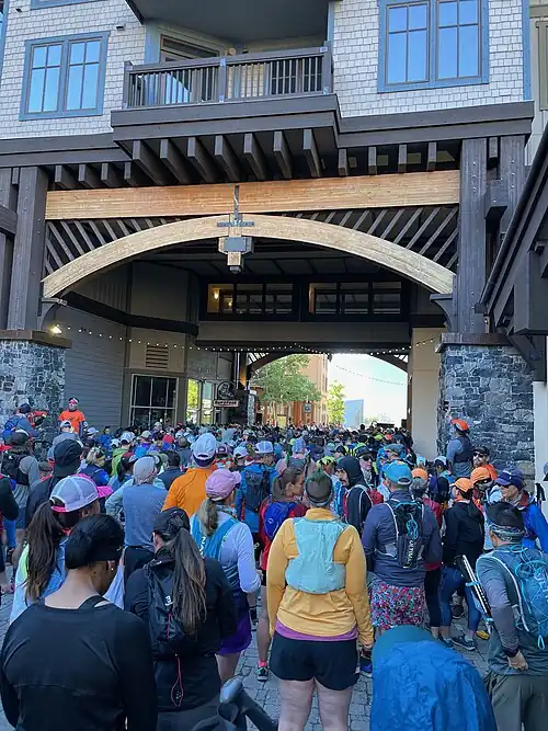 Coureurs attendant le départ d'une course à pied sour le passage voûté d'un bâtiment.
