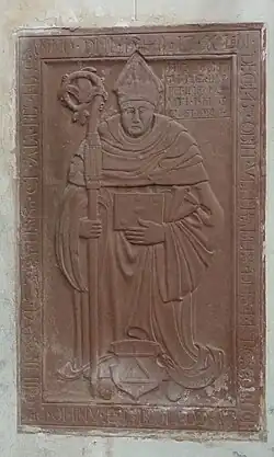 Photographie d'une épitaphe représentant un ecclésiastique portant crosse et mitre.