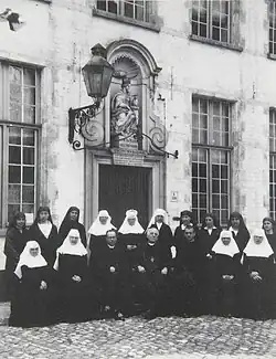 Réunion en 1926 des béguines de Bruges et des Filles de saint Benoît de Nîmes, rassemblées autour de trois prélats (Don Gaspar Lefebvre à gauche, Rodolphe Hoornaert à droite, et un prélat britannique au centre)