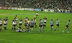 Joueur des deux équipes, lors d'un arrêt de jeu, deux hommes se relevant.