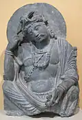 Bodhisattva Avalokiteshvara (padmapani : porteur de lotus), pensif (ou Maitreya) Schiste. Gandhara, IIe – IIIe&nbsp;siècle. Musée de l'Ermitage