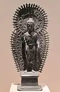 Bouddha debout avec halo et mandorle à rayons. Statuette portative. Gandhara, v. fin VIe&nbsp;siècle. Laiton, H. 33,7&nbsp;cm. Met.