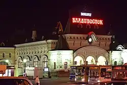 Gare de nuit avec des bus garés en premier plan sur le parking