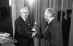 Walter Hallstein on stage, shaking hands while receiving prize.