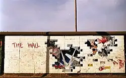 Mur en briques blanches avec, de gauche à droite, le nom de l'album, un trou avec des marteaux qui marchent à l'unisson, des faisceaux lumineux pointant sur une petite personne et un juge gigantesque avec des fesses à la place de la bouche, ainsi que plusieurs autres trous dans le mur avec divers personnages, tels qu'une femme-scorpion.