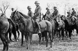 Photo noir et blanc montrant un groupe d'hommes en uniforme et à cheval.