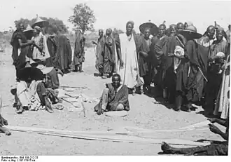 Mesure de bandes de coton tissé au marché de Mora vers 1911-1915.