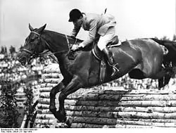 Photo d'un Hanovrien franchissant un mur dans une épreuve des Jeux Olympiques d'été 1964.
