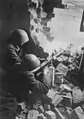 6. Début avril 1945, deux hommes du Volkssturm équipés de casques tchèques durant les combats en Silésie. Ils sont armés d’une mitrailleuses MG 15