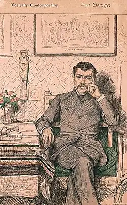 Bourget assis dans son bureau sur un fauteuil, sa main gauche sert d'appui à sa tête. Tableau de Botticelli et statue antique égyptienne en arrière-plan, bouquet de fleurs sur une table.