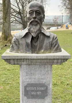 Photographie d'un buste placé sur un piédestal.