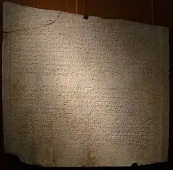 Photographie d'une plaque de pierre faisant figurer un texte en grec.