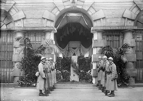 Photographie en noir et blanc de soldats formant une haie d'honneur.