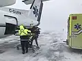 Transbordement d'un patient dans un Dash-8-300 du Service aérien gouvernemental (SAG) du Québec, lors d'une escale aux Îles de la Madeleine