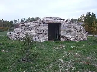 Cabane en pierre sèche moderne édifiée sur le rond-point de l'entrée de l'aéroport de Brive-Vallée de la Dordogne.