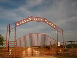 Un portail d'accès à une propriété surmonté de l'inscription Cactus Jack Ranch.