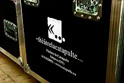 Une caisse de tournée du Théâtre Catapulte avec l'ancien logo de la compagnie.