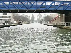 Le canal de l'Ourcq à Pantin. Au fond, la silhouette des Grands moulins de Pantin